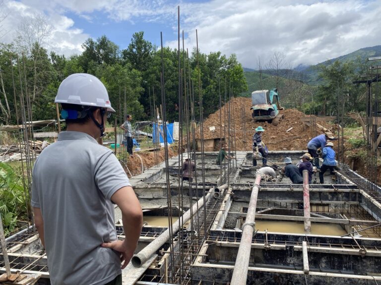 Đổ bê tông móng công trình nhà ở, có kỹ sư đội mũ bảo hộ giám sát tại hiện trường