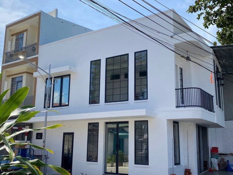Mặt tiền nhà hai tầng hoàn thiện, cửa kính lớn khung nhôm đen