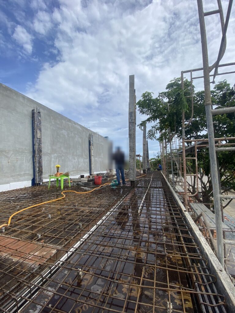 Thép dầm và sàn đã đan xong, cột chờ vươn lên dọc tường rào