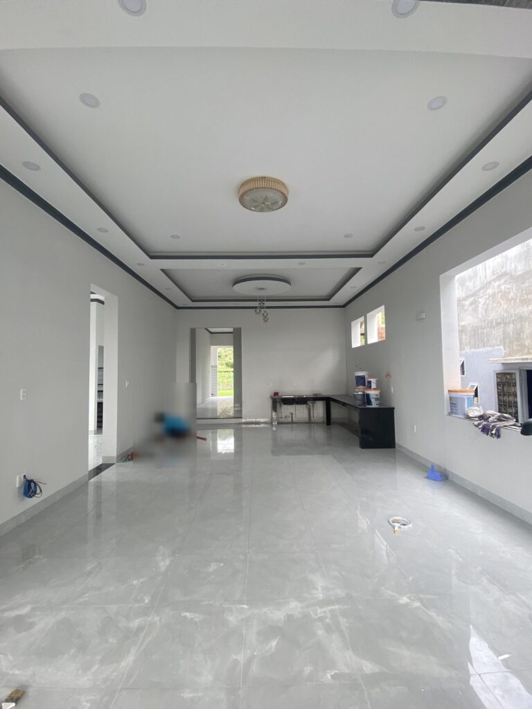 Không gian trệt đã lát gạch bóng, trần thạch cao giật cấp, đang vệ sinh bàn giao