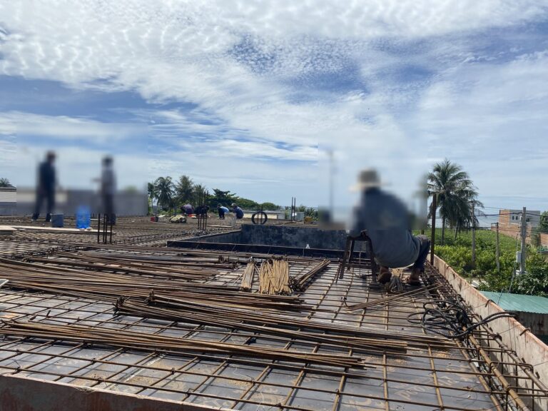 Thép sàn mái tập kết trên cốp pha, phía xa là hàng dừa ven biển