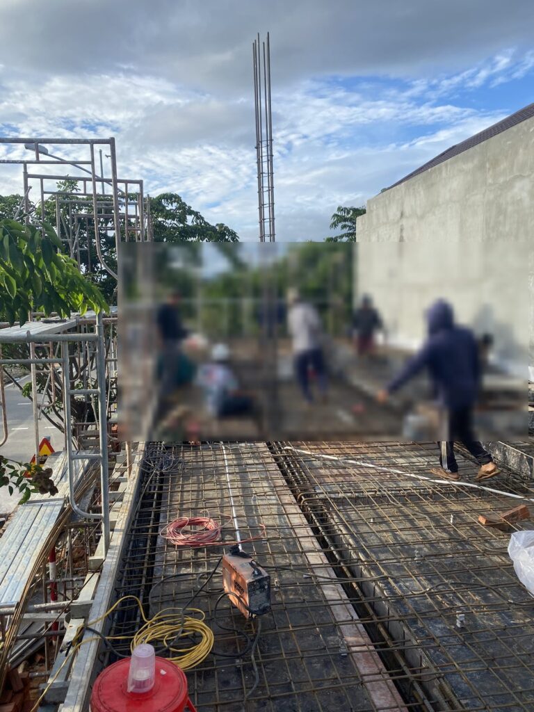 Nhiều thợ cùng lắp thép sàn, cuộn dây điện và máy móc tại chỗ